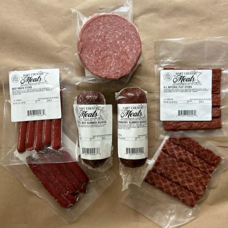 Contents of the You Had Me at Charcuterie Box including 1 All Natural All Beef Summer Sausage, 1 All Natural Cranberry Summer Sausage, 1 Cotto Salami, 2 All Natural Flat Strips, and 2 packs of snack sticks