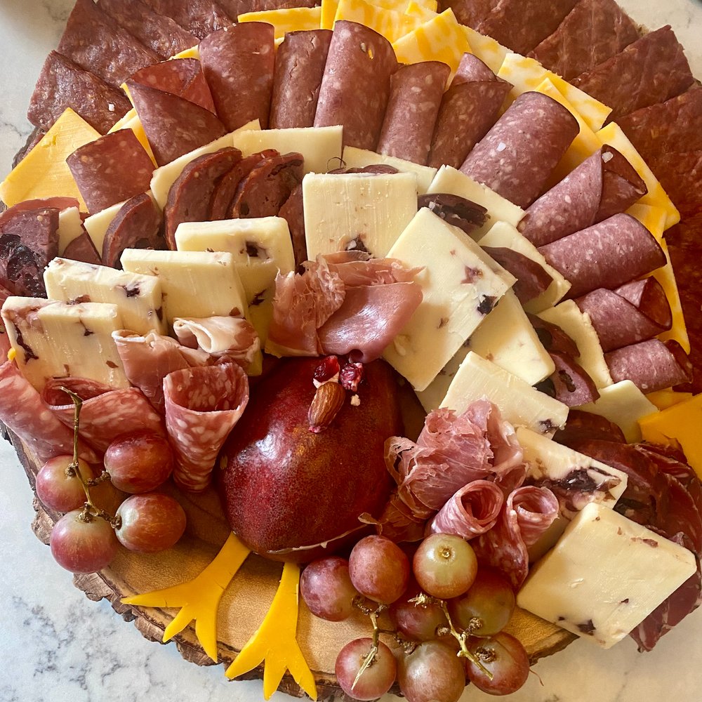 Contents of the You Had Me at Charcuterie Box including 1 All Natural All Beef Summer Sausage, 1 All Natural Cranberry Summer Sausage, 1 Cotto Salami, 2 All Natural Flat Strips, and 2 packs of snack sticks