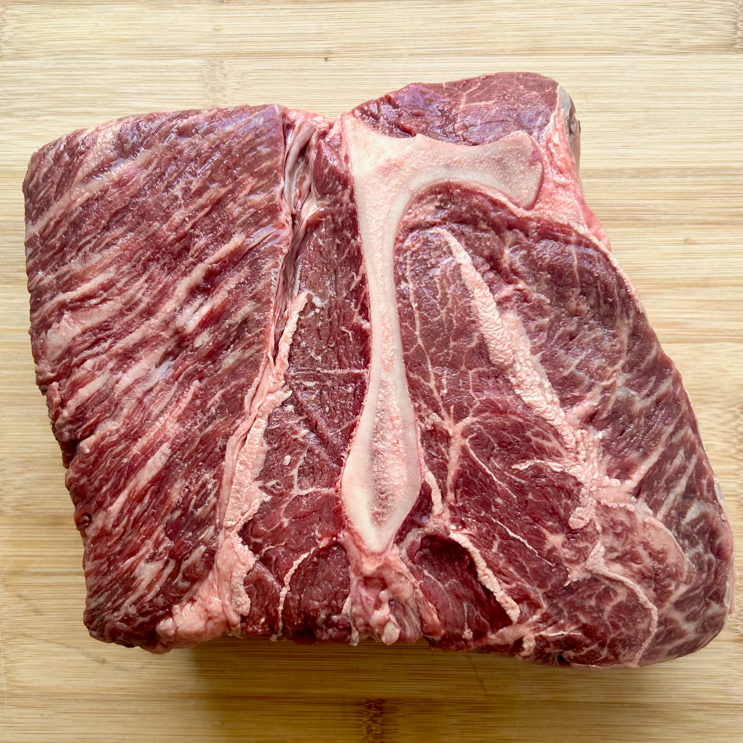 Unwrapped wagyu cross beef chuck roast from Remmele Custom Beef on a cutting board